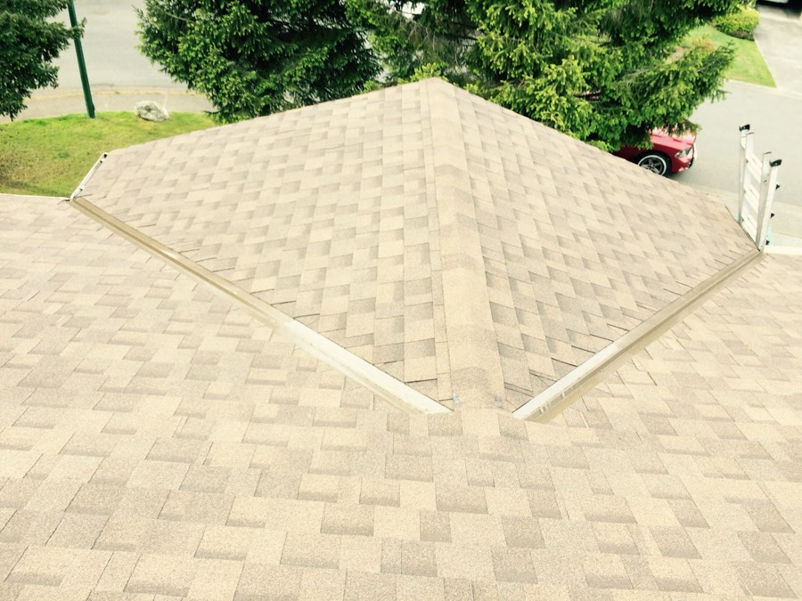 Freshly laid asphalt shingles across a hip roof