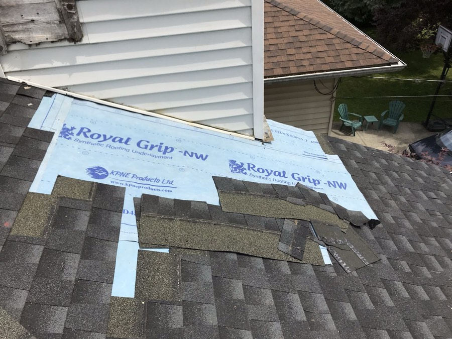 Underlayment being rolled out over the roof deck before shingles