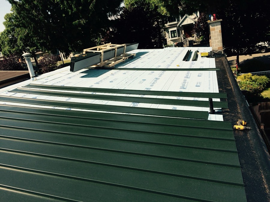 Metal roof panels part way through installation with underlay exposed